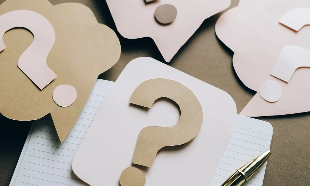 Notebook and question marks representing bet22 account and payment FAQs