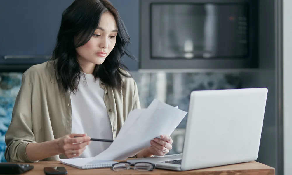 Person reviewing offer terms beside a laptop before accepting a bonus